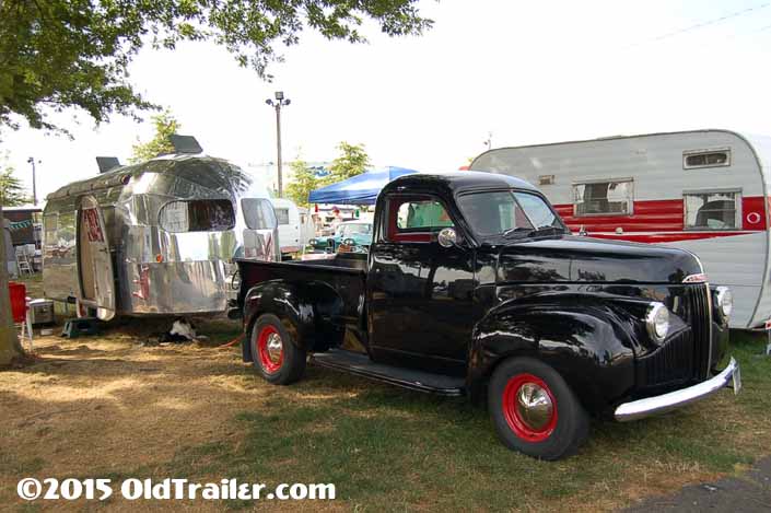 This vintage towing rig is a studebaker pickup truck pulling a 1949 curtis wright vintage trailer