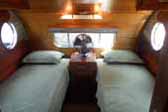Warm and inviting rear bedroom with twim beds in a 1950 Airfloat vintage travel trailer