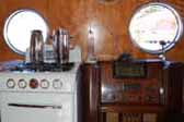 Great vintage gas stove and console radio in wood cabinet, in a restored 1952 Airfloat travel trailer