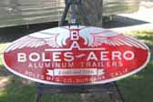 Cool large reproduction Boles Aero factory id plate next to a 1952 Boles Aero Montecito trailer