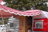 Picture of 1954 Dalton vintage trailer with a red and white peppermint striped canvas side awning