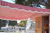 Close up picture of a 1954 Dalton vintage trailer with a red and white striped awning
