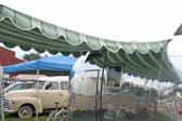 1960 Airstream Caravel trailer with a dark green and light green striped canvas awning