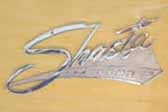 Re-chromed cast Shasta logo script emblem on the side of a 1962 Shasta Compact vintage trailer