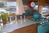 Photo shows the kitchen cabinets and interior of an Aladdin vintage trailer, the small Genie model