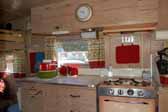 Photo shows the cabinets and wood work in the galley area of an Aladdin Magic Carpet trailer