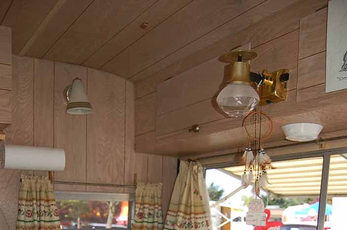 Photo of the original propane light fixture over the dining table in an Aladdin Magic Carpet Model Trailer