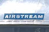 Vintage Airstream travel trailer with the famous Aitrstream blue logo graphics decal on the front