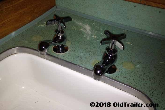 Photo shows the new faucets temporarily in place and the epoxy repairs in the formica counter are almost done