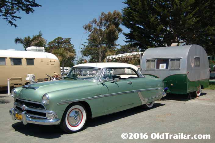 This vintage towing rig is a hudson hollywood 2-door hardtop pulling a vintage travel trailer