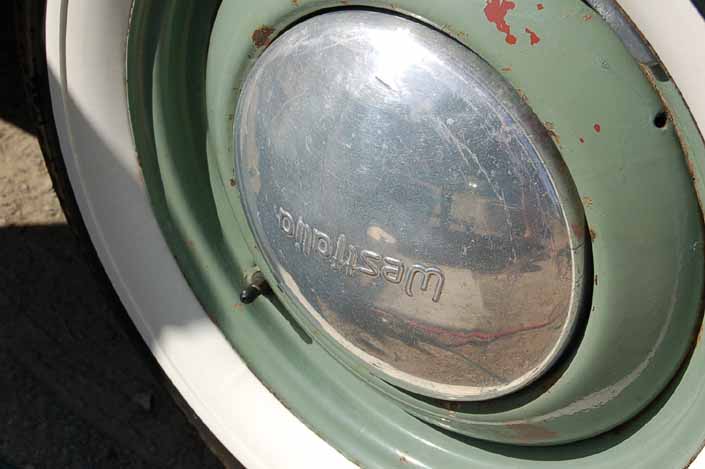 This example shows what vintage trailer wheels painted green look like with large chrome hubcaps