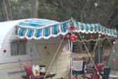 Picture of a vintage 1950s Shasta trailer at the Spamboree Rally, with a green, turquoise and white striped side awning