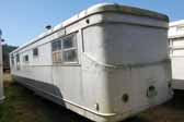 Photo of the rear end of a Spartan Manor trailer awaiting restoration in a vintage trailer junk yard
