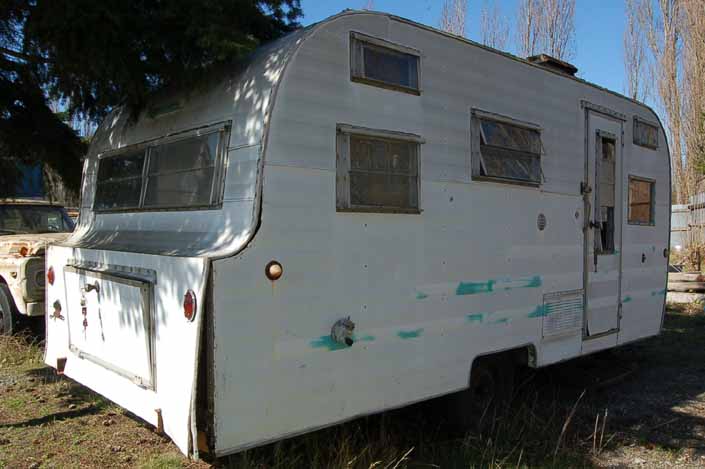 Vintage trailer junkyard has a derelict vintage Nomad travel trailer ready for restoration
