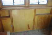 Photo shows original woodwork and cabinets in a restorable 1948 Westcraft Westwood Trailer