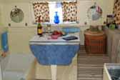 Photo shows the dining area of a 1935 Masterbilt Pioneer Trailer, with bathtub hidden one of the dining room bolsters
