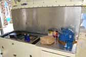 Picture of the galley in a 1935 Masterbilt Pioneer Trailer, showing the cooktop and restored painted kitchen cabinets