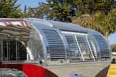 Front curved window and polished louver panels on a restored Aero Flite Travel trailer