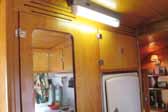 Photo shows the original ceiling light fixture in a vintage 1948 Vagabond trailer hallway