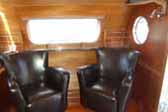 Living room with classic leather arm-chairs in 1950 Airfloat Land-Yacht vintage trailer