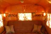 Photo shows the warmly inviting living room in a restored 1950 Vagabond trailer