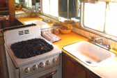 Photo shows kitchen with bright yellow plastic laminate counter in a 1950 Vagabond trailer