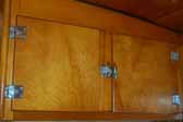 Photo shows kitchen cabinets with original hinges and latches in a 1951 Vagabond trailer