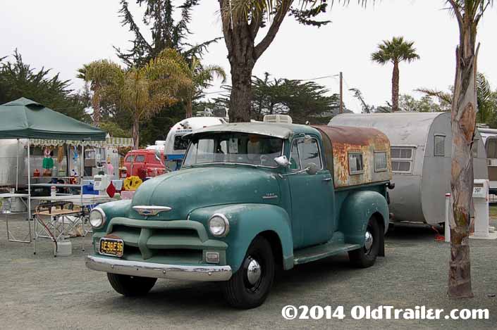 This vintage towing rig is a 1954 chevy pickup truck pulling a vintage canned ham trailer