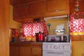 Beautifuly decorated and restored kitchen cabinet woodwork in 1955 vintage Aljoa trailer