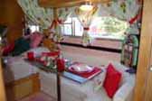 Photo shows beautifully decorated dining area in 1955 vintage Aljoa trailer