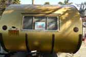 Beautiful 1957 Airfloat Cruiser trailer with stock gold aluminum siding and curved protective ribs on rear-end