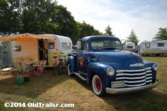 This vintage towing rig is a chevy pickup truck pulling a vintage 1958 aloha trailer