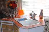 Photo of the beautifully mid-century angled kitchen counter top and cabinets in a rare 1961 vintage Holiday House trailer 24-ft.