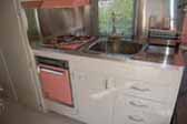 Photo of kitchen cabinets and amazing stainless steel counter top in 1961 Holiday House vintage trailer