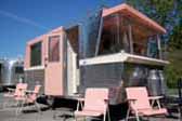 Photo of beautifully restored 1961 Holiday House travel trailer painted bright pink and white