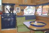 Bold dark blue appliances and design accents in 1961 Shasta Compact vintage trailer