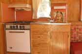 Photo of Restored kitchen woodwork and appliances in 1962 Holiday House Model-18 trailer
