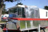 Photo of front end of 1962 Holiday House vintage trailer, painted red and white colors