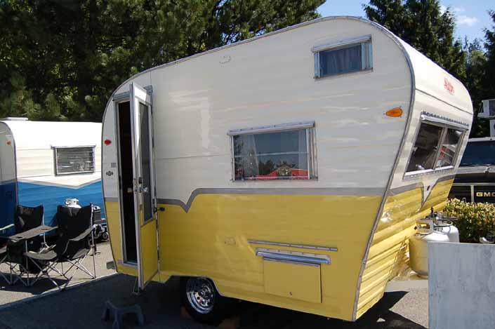 Photo of a very cute yellow and white Genie model vintage Aladdin travel trailer