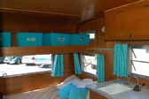 Bedroom area with plenty of storage above, in the interior a nicely restored Aladdin vintage trailer