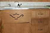 Close-up photo of the Aladdin's lamp outline cut into the kitchen cabinet of a vintage Aladdin Genie trailer by the Aladdin factory