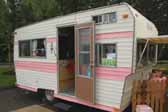 Great pink and white retro paint job on the exterior of a vintage Aladdin trailer