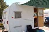 Clean vintage Aloha travel trailer with striped canvas side awning