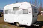 Photo of unrestored vintage Aloha trailer with original quilted aluminum side panel