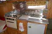 Beautiful kitchen countertop, stove and cabinets in vintage Aloha travel trailer