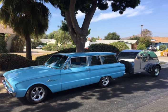 This vintage towing rig is a classic ford 2-door station wagon pulling a vintage tear-drop trailer