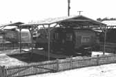 Historical photo shows a wooden shade cover built over a beautiful 1940's vintage trailer, at the Hanford Trailer Camp in Washington