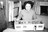 Old photo shows a woman proudly displaying her scale model travel trailer, at Project Hanford Trailer City