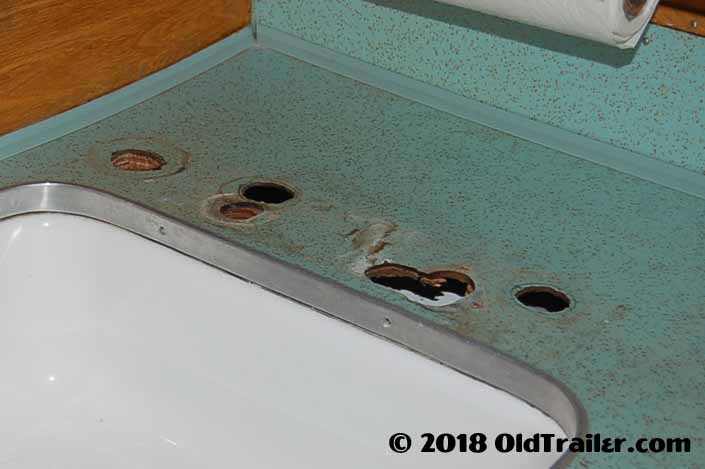 Photo shows huge holes in a vintage Formica countertop, that we'll show you how to patch yourself