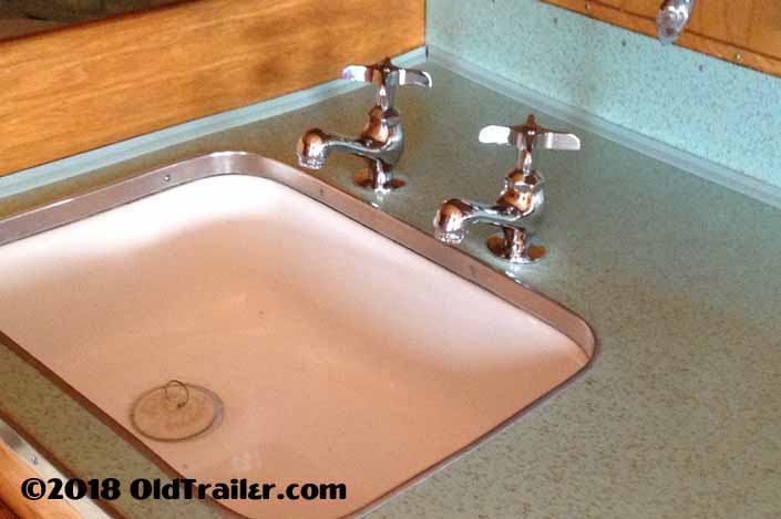 This final photo shows that the repairs to the vintage formica look great and are barely noticeable next to the new faucets in the formica countertop